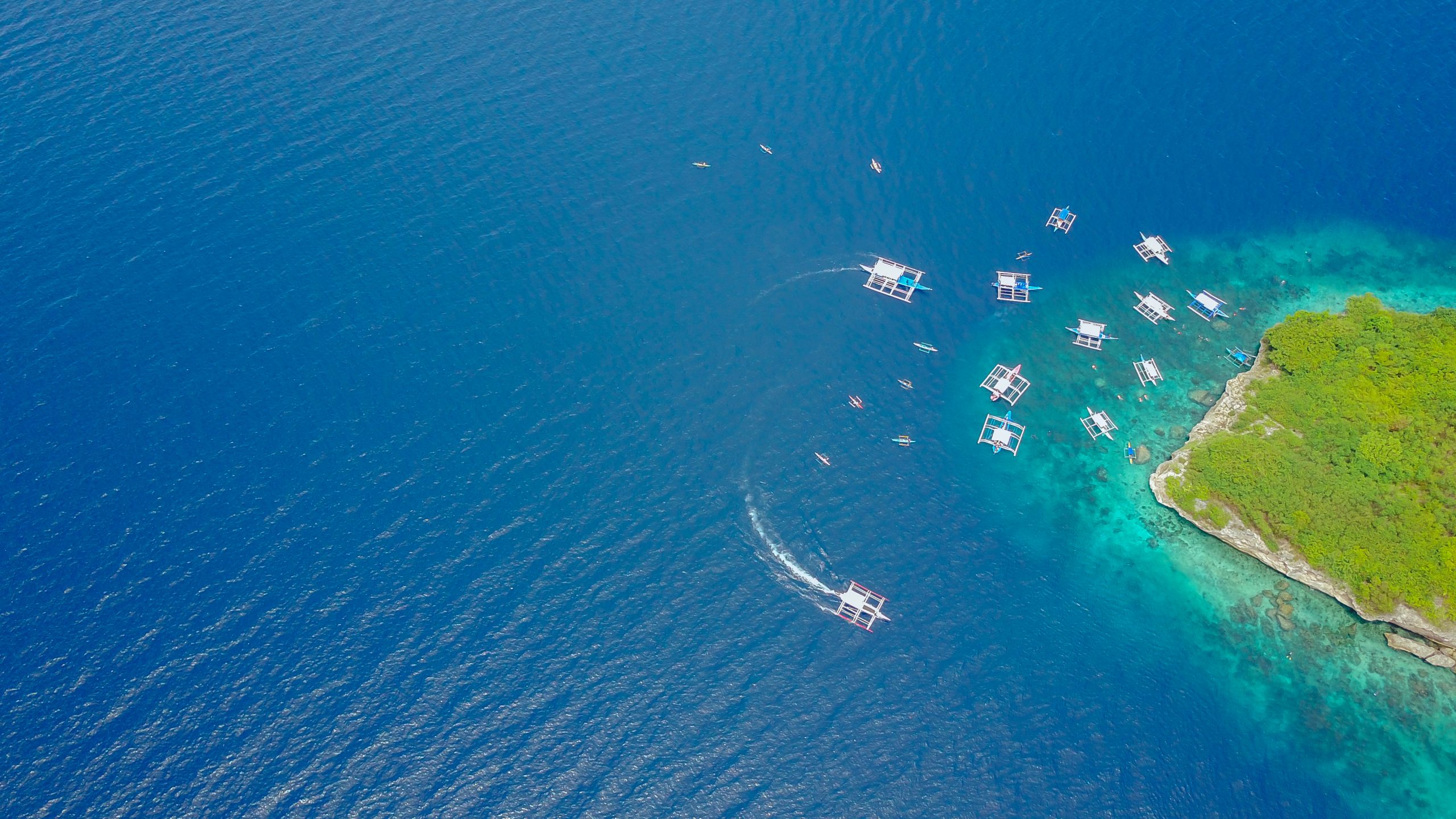 Aerial view of sandy beach with tourists swimming in beautiful clear sea water of the Sumilon island beach landing near Oslob, Cebu, Philippines. - Boost up color Processing.